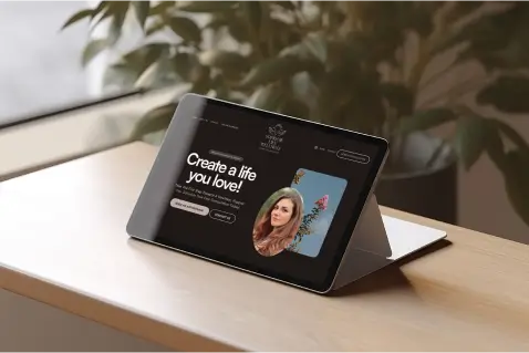 Tablet displaying a modern therapy website design featuring the text "Create a life you love" and a professional photo of a woman, set against a backdrop of greenery.
